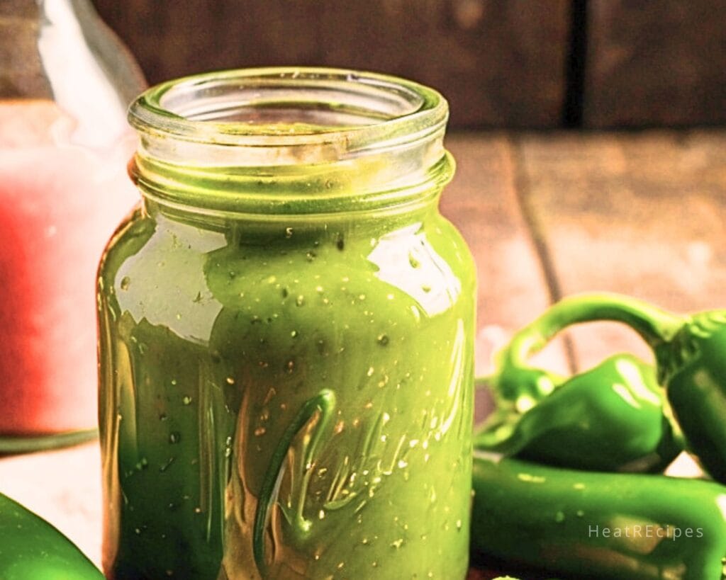 Glass jar filled with freshly made jalapeno hot sauce