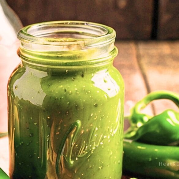 Glass jar filled with freshly made jalapeno hot sauce