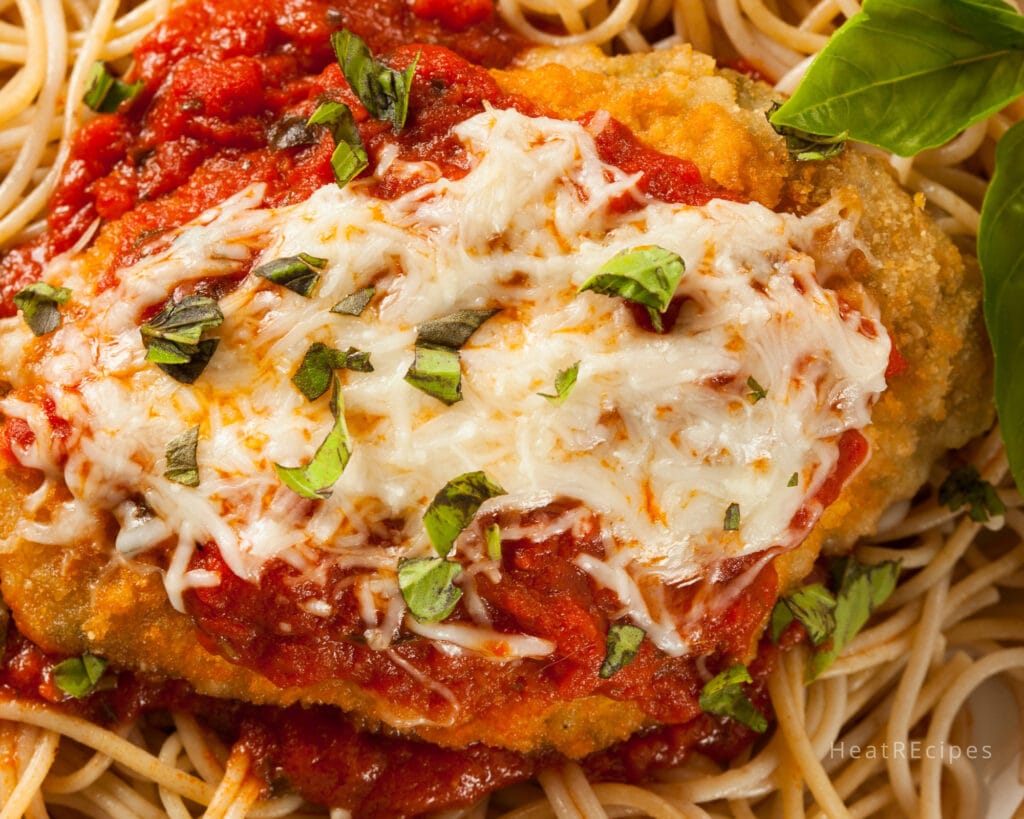 Chicken Parmesan cooked with tomato sauce