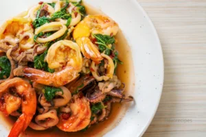 A plate of seafood with Bloves Sauce dipping bowl