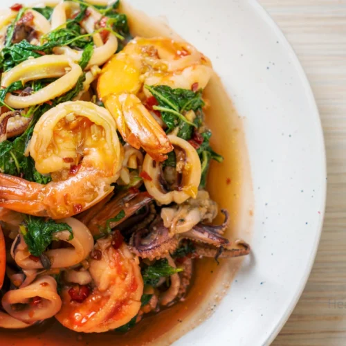 A plate of seafood with Bloves Sauce dipping bowl